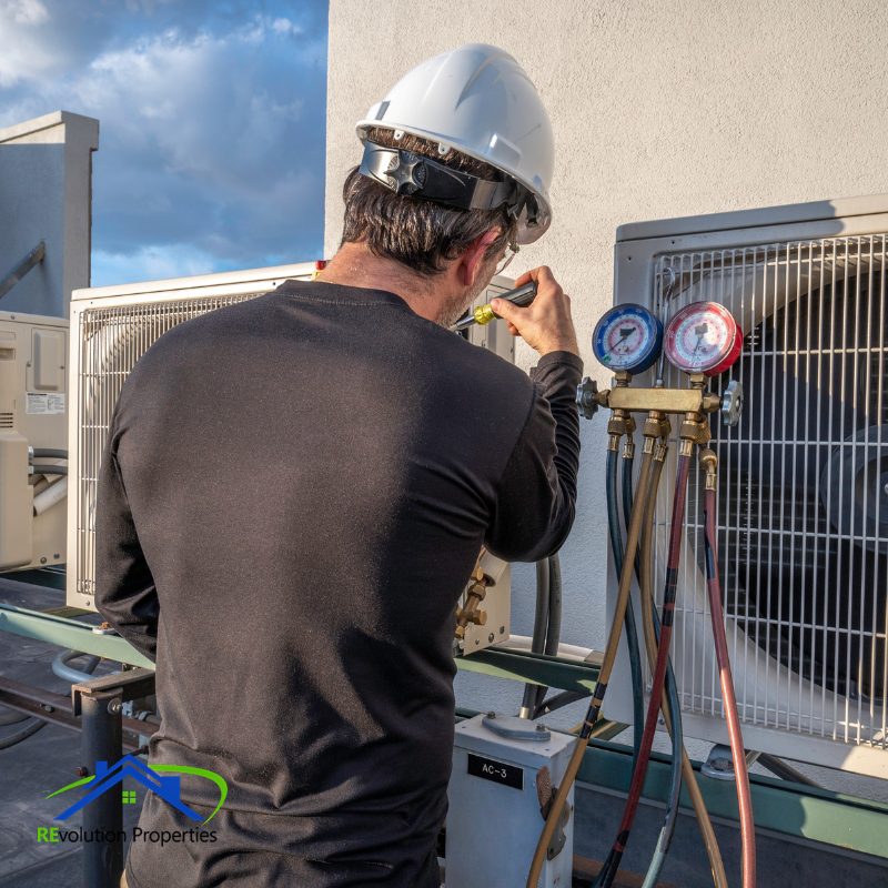 property manager Technician fixing an HVAC unit Property management technician performing HVAC system maintenance on rooftop unit