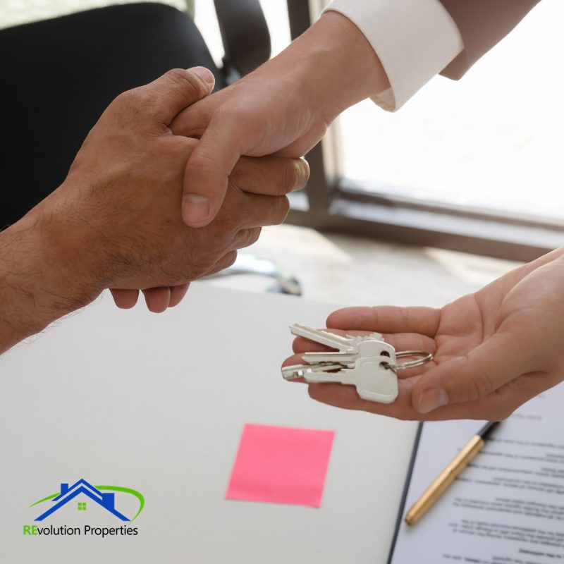 tenant Signing a Lease Property manager handing over keys to new tenant at Revolution Properties